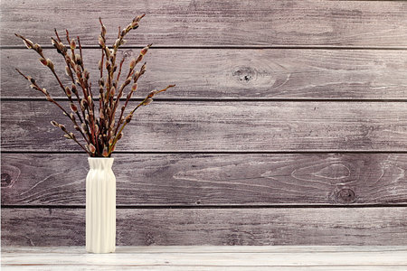 Delicate pussy willow flowers in vase on wooden background, abstract spring floral arrangement. Easter card and still life, minimal holiday concept, home interior, selective focusの写真素材