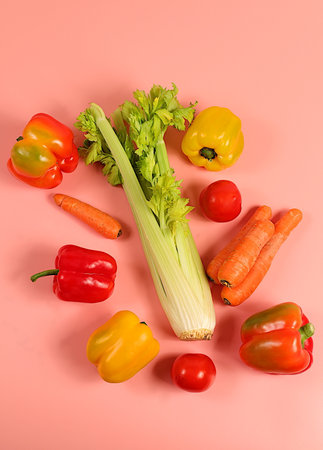 Sweet bell peppers, tomatoes, celery and carrots on a light table. Modern still life of various ripe vegetables for healthy vegetarian food and detox diet, harvest. Advertisement of a store and marketの写真素材