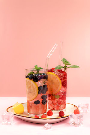 Modern still life with berry juice, raspberries, blueberries, red currants and oranges on elegant...