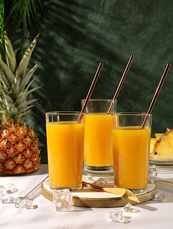 Fresh pineapple smoothie or juice with pineapple and mango slices, modern still life with tropical fruits. Summer vacation and detox diet concept. Flyer for a cafe or restaurant, summer postcardの写真素材