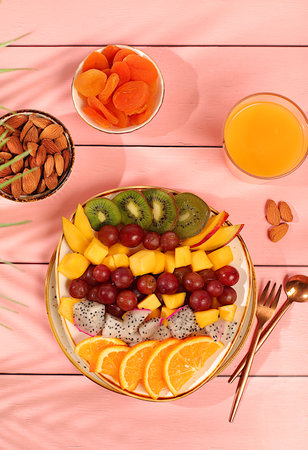 Fruit salad with kiwi, mango, dragon fruit, grapes, nuts, citrus fruits with chia seeds for weight...