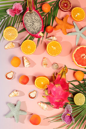 Tropical background with exotic fruits, Sunny banner. Summer in a snapshot, Dragon fruit, pitaya, oranges, apricots, orchid flowers, grapefruit and seashells on palm leaves, template for your designの写真素材