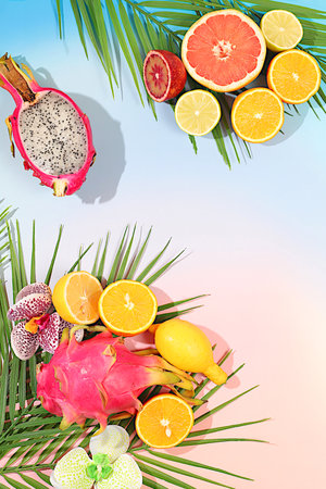 Dragon fruit, pitaya, oranges, lemons, orchid flowers on palm leaves, tropical background with palm trees and exotic fruits, beautiful template for your design, bright sunny banner, summer in a snapshot.の写真素材