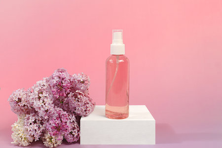 Advertising postcard of spa salon. Wellness composition with lilac water and fresh lilac flowers, Concept of natural self-care and healthy lifestyle, abstract composition with flowersの写真素材