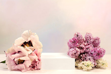 Empty podium with spring lilac flowers and mountain peony.Abstract floral arrangement with lilac flowers, banner. Creative template for your design.Minimal modern aesthetics, elegant beauty concept,の写真素材