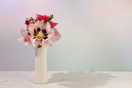 Still life with spring flowers mountain peony and columbine in vase on elegant modern table,template for your design with space for text,minimal beauty concept,beautiful flower card,abstract flower arrangementの写真素材