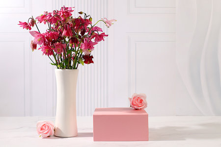 Abstract flower arrangement with empty podium for product display, template for display, Beautiful spring blooming columbine on sunny background, banner, still life with place for text, advertising flyerの写真素材
