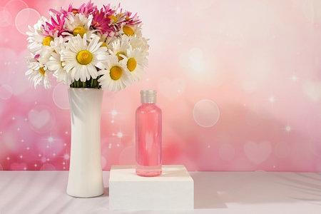 Wellness composition with rose water and fresh flowers of garden chamomile and mallow, spa salon advertising card, natural self-care and healthy lifestyle concept, abstract composition with flowersの写真素材