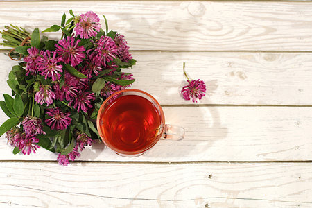 Clover infusion in a glass with a bouquet of flowers, Medicinal herbal tea, the concept of...