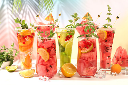 Modern still life with alcoholic cocktail of watermelon, apricot lemon, ice, tequila, vodka and mint...