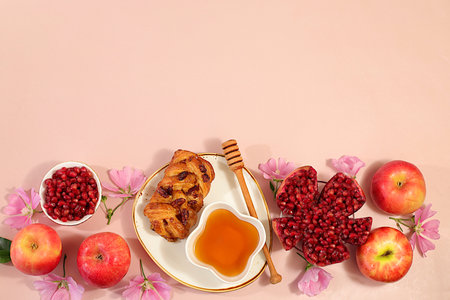 Jewish holiday Rosh Hashanah concept with apples, honey, pomegranate, challah bread and flowers for greeting card, creative layout and template for Jewish New Year, autumn banner for designの写真素材