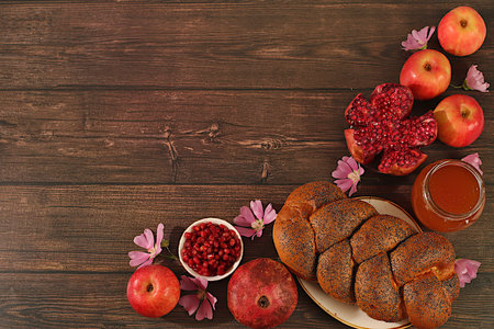 Creative composition for the Jewish holiday Ro Hashanah. Layout with traditional symbols of the Jewish New Year, template with honey, apples, pomegranate, flowers and challah bread for a holiday card, banner.の写真素材