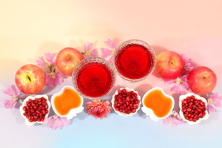 Layout with symbols of the Jewish New Year, template with honey, apples, pomegranate, and flowers. Creative composition for congratulations on the Jewish holiday Ro hashanah, autumn banner for advertising.の写真素材