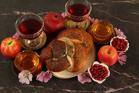 Creative autumn composition for the Jewish holiday Ro Hashanah. Layout with symbols of the Jewish New Year, template with honey, apples, pomegranate, red wine, challah bread and flowers for a holiday card,の写真素材
