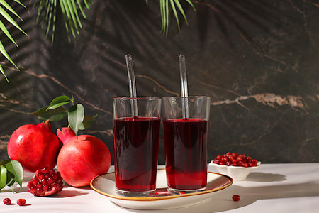 Pomegranate juice drink and ingredients, rich pomegranate drink on elegant sunny table, detox diet...