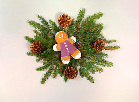 Beautiful holiday decoration made of live fir branches, gingerbread and pine cones, isolated on a...