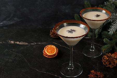 Christmas martini with cinnamon, nutmeg, and dark chocolate against a backdrop of fir branches, a Christmas and holiday concept. A warming milk drink during the cold season, a Christmas Eve concept.の写真素材
