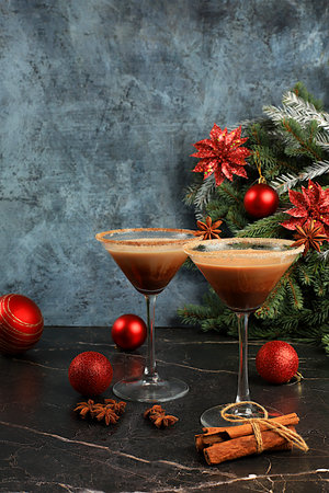 Christmas martini with cinnamon, nutmeg, and dark chocolate against a backdrop of fir branches, Christmas and holiday concept. A warming milk drink during the cold season, Christmas Eve concept.の写真素材