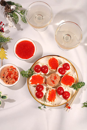 French baguette with smoked salmon pate, red caviar, soft cheese and tomatoes, Christmas Eve concept, restaurant and cafe menu. Christmas and New Year dishes, a set of canapes for festive tables and receptions,an idea for cookingの写真素材