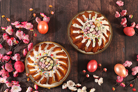Abstract Easter composition featuring a traditional Russian meringue kulich and decorated eggs on an...