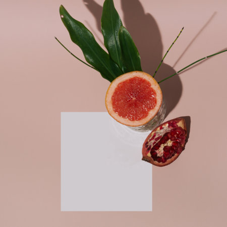 Summer tropical composition made with fresh fruit and green leaves on pastel pink background. Minimal flat lay with white space.の写真素材