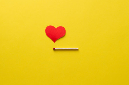 Matchstick and red heart-shaped flame. Minimalist composition.の写真素材