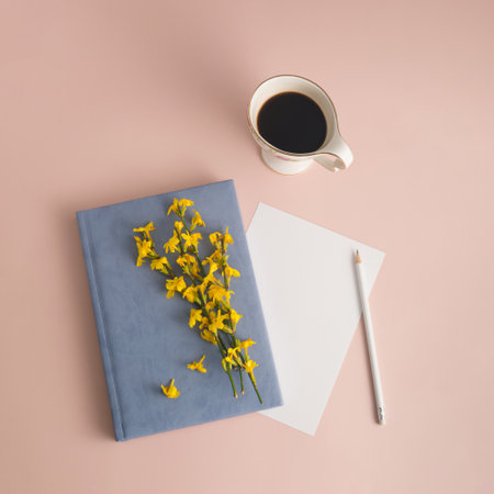 Flat lay view of student desk. Working atmosphere cup of coffee, notebook, pencil and spring flower....