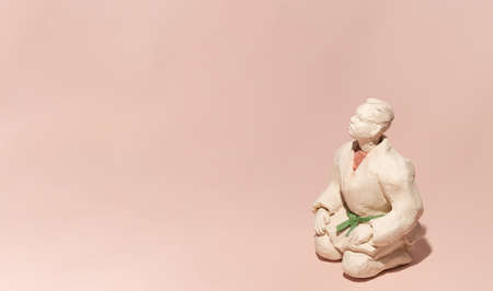 A martial arts fighter setting on a pastel pink background.の写真素材