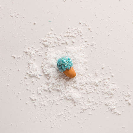 Acorn seed in blue stone glitter texture laying down on snow. Aesthetic layout.