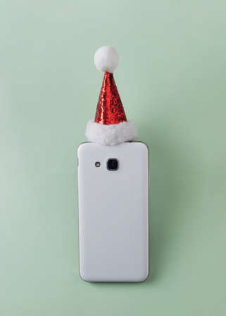 A phone with Christmas balls on a green background.の写真素材