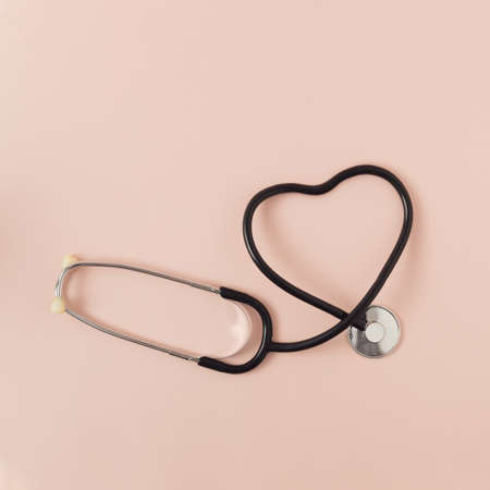 A surface stethoscope creates a heart shape on pink background. World Health Day.の写真素材