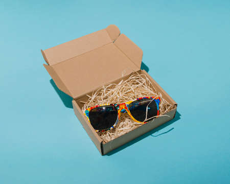 Colorful summer sunglasses in a box on a blue backgroundの写真素材