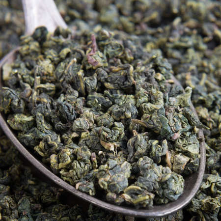 Green tea on metal spoonの写真素材