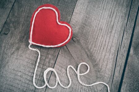 Red heart on vintage table with text with copy space.