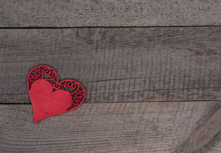 Valentine's day. Wooden carved heart over wooden table background with copy space.
