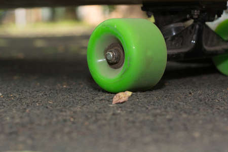 Old used skateboard isolated on the ground. Old style longboard. Black skateboard on an empty...