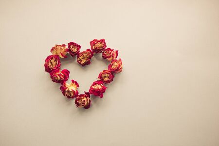 Valentines card. Heart symbol made of dried roses on a vintage background. Top view, flat lay. Concept, postcard with place for your text. Vintage filter.の写真素材