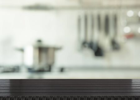 Blurred and abstract background. Empty wooden tabletop and defocused modern kitchen background for display or montage your products.の写真素材