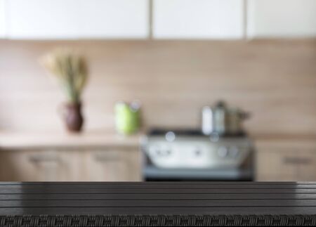 Blurred and abstract background. Empty wooden tabletop and defocused modern kitchen background for display or montage your products.の写真素材