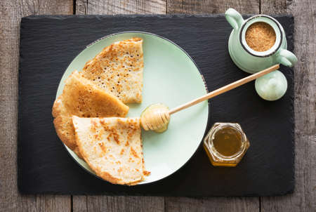 Tasty traditional russian pancakes on dish with honey. Rustic style. Space for your text.の写真素材