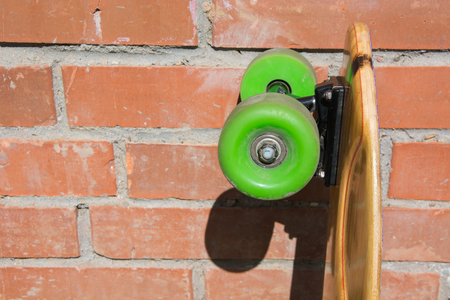 Longboard and green whels on the bricks background. Shallow depth of field. Close up.の写真素材