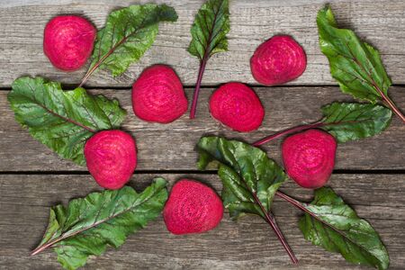 Raw beetroots sliced and mangold leaves on rustic board . View from above.  Vegetables background....