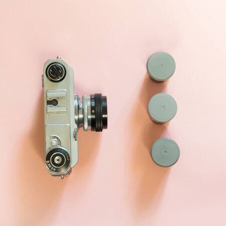 Old retro camera with three box for film on pink background. Concept.