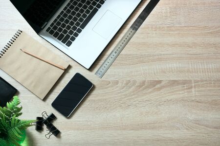 Open laptop and messthetics objects on office wooden desk table. Top view and copy space.