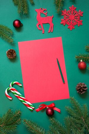 Christmas red blank for letter to Santa or your wishlist or advent activities on green. Top view.の写真素材