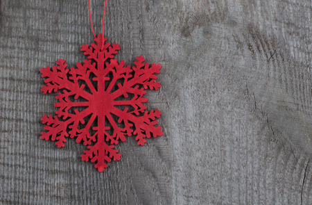 Wooden red christmas snowflakes. Decoration on wooden background. Top view with copy spaceの写真素材