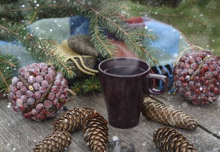 Ð¡up of hot tea on a rustic wooden table. Still life of cones, twine, patskthread, fir branches. Preparing for Christmas.  Effect Drawn Snowの写真素材