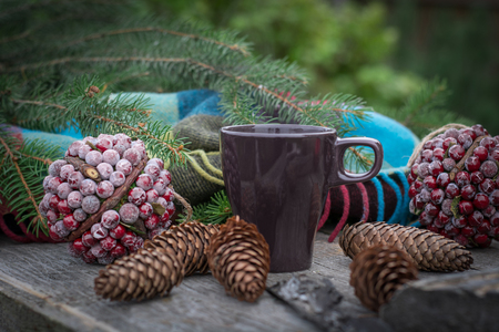 Cup of hot tea on a rustic wooden table. Still life of cones, twine, patskthread, fir branches. Preparing for Christmas.の写真素材
