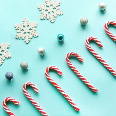 Merry Christmas candy can in row on blue background. Flat lay. Square image. Pattern.