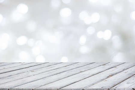 Wooden white table top on abstract white bokeh. Christmas and festive theme background.の写真素材